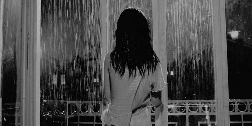 A woman with her back to the camera looking out the window in The Housemaid