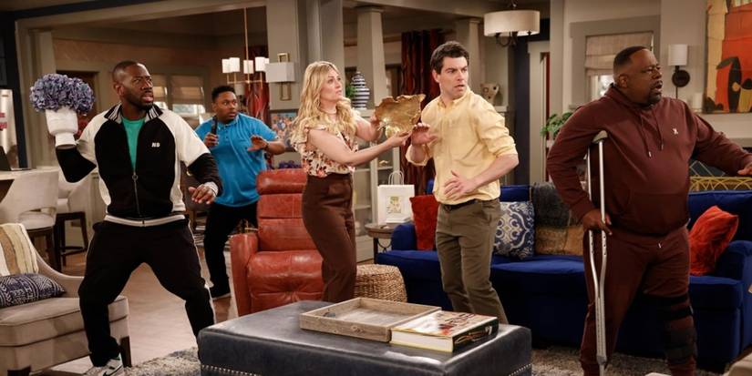 The cast react to something off-camera and all look in the same direction in The Neighborhood.