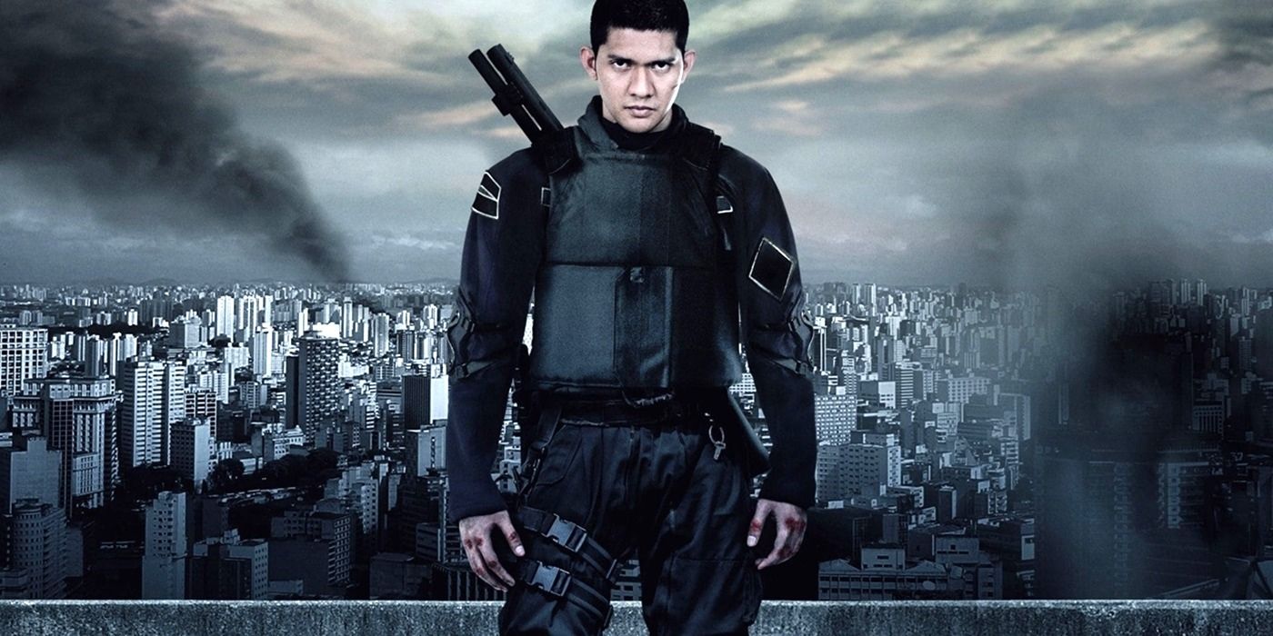 Iko Uwais on a cropped poster for The Raid 2 with the city skyline behind him