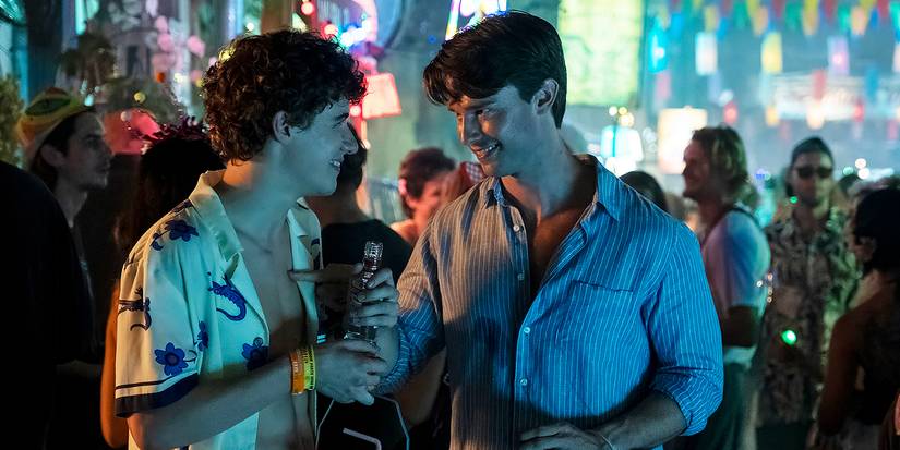 Sam Nivola and Patrick Schwarzenegger smiling at each other and drinking in Thailand in The White Lotus.