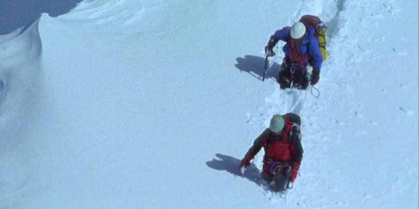 Two climbers walk through thigh deep snow