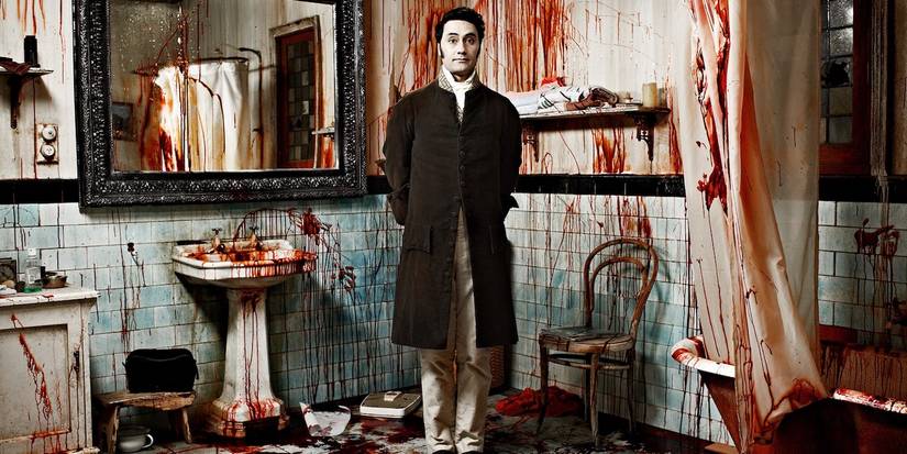 Viago (Taika Waititi) stands in a blood-soaked bathroom in What We Do in the Shadows.