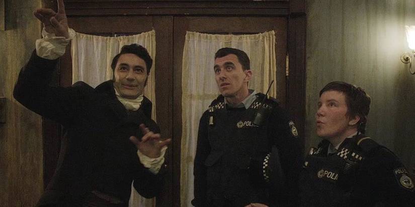 Viago (Taika Waititi) talks to Officer O'Leary (Karen O'Leary) and Officer MInogue (Mike Minogue) in What We Do in the Shadows.