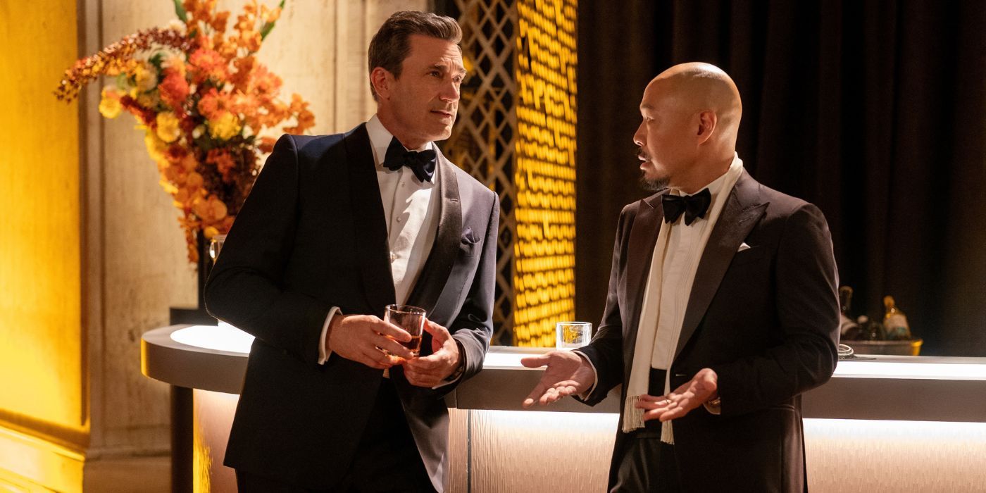 Jon Hamm as Coop, wearing a tux while leaning on a bartop, while talking to Hoon Lee as Barney in Your Friends and Neighbors.