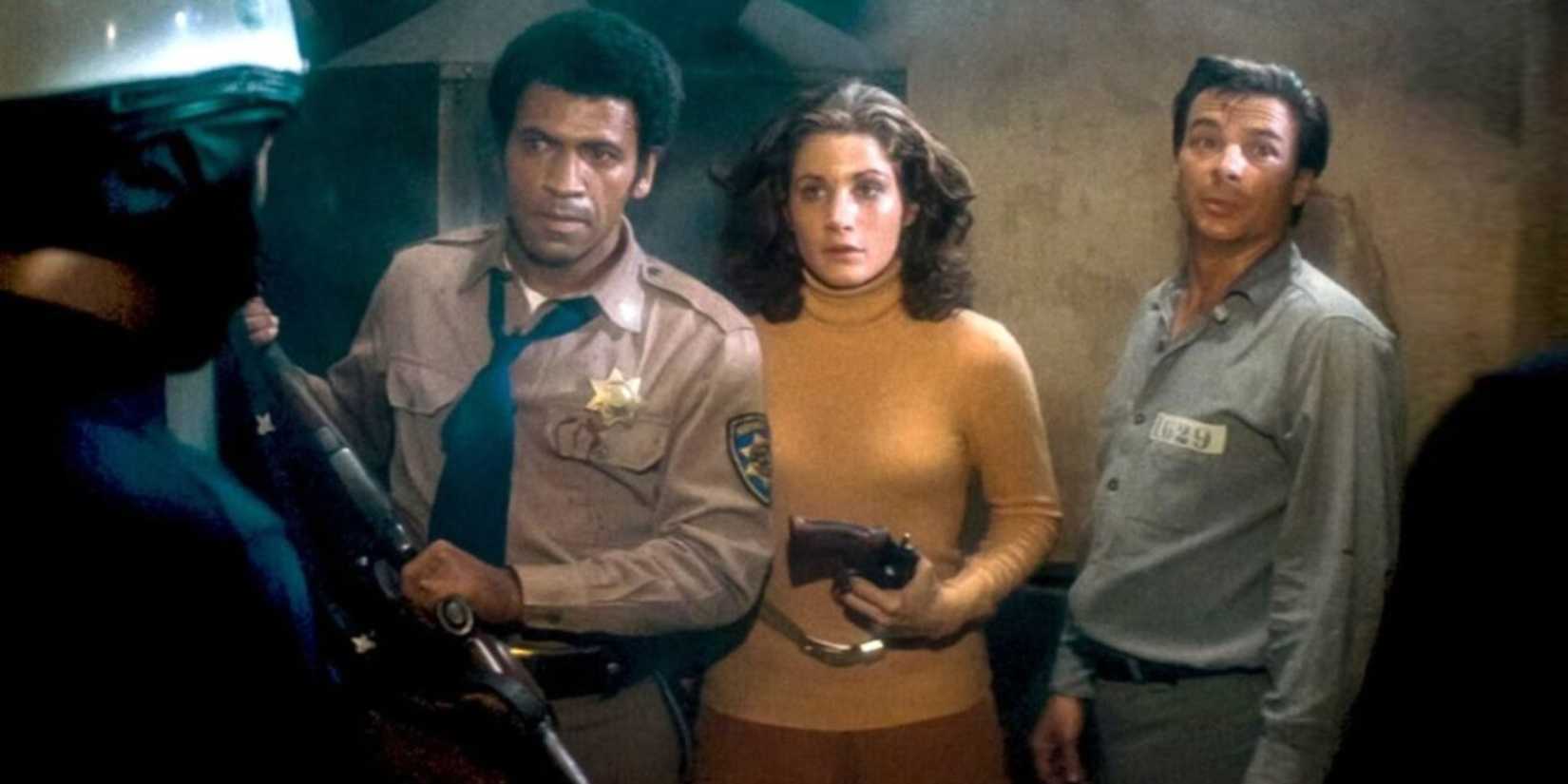 Two men and a woman looking at a cop in Assault on Precinct 13