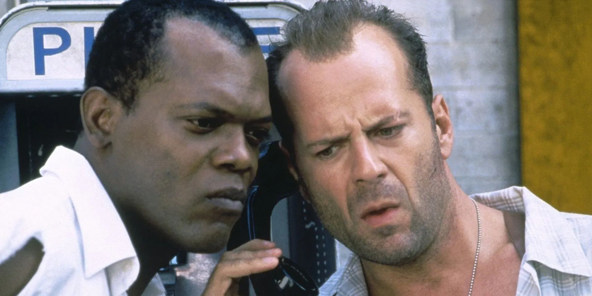Bruce Willis as John McClane and Samuel L. Jackson as Zeus Carver listen to instructions from Jeremy Irons as Simon Peter Gruber over a NYC payphone in 'Die Hard With a Vengeance'