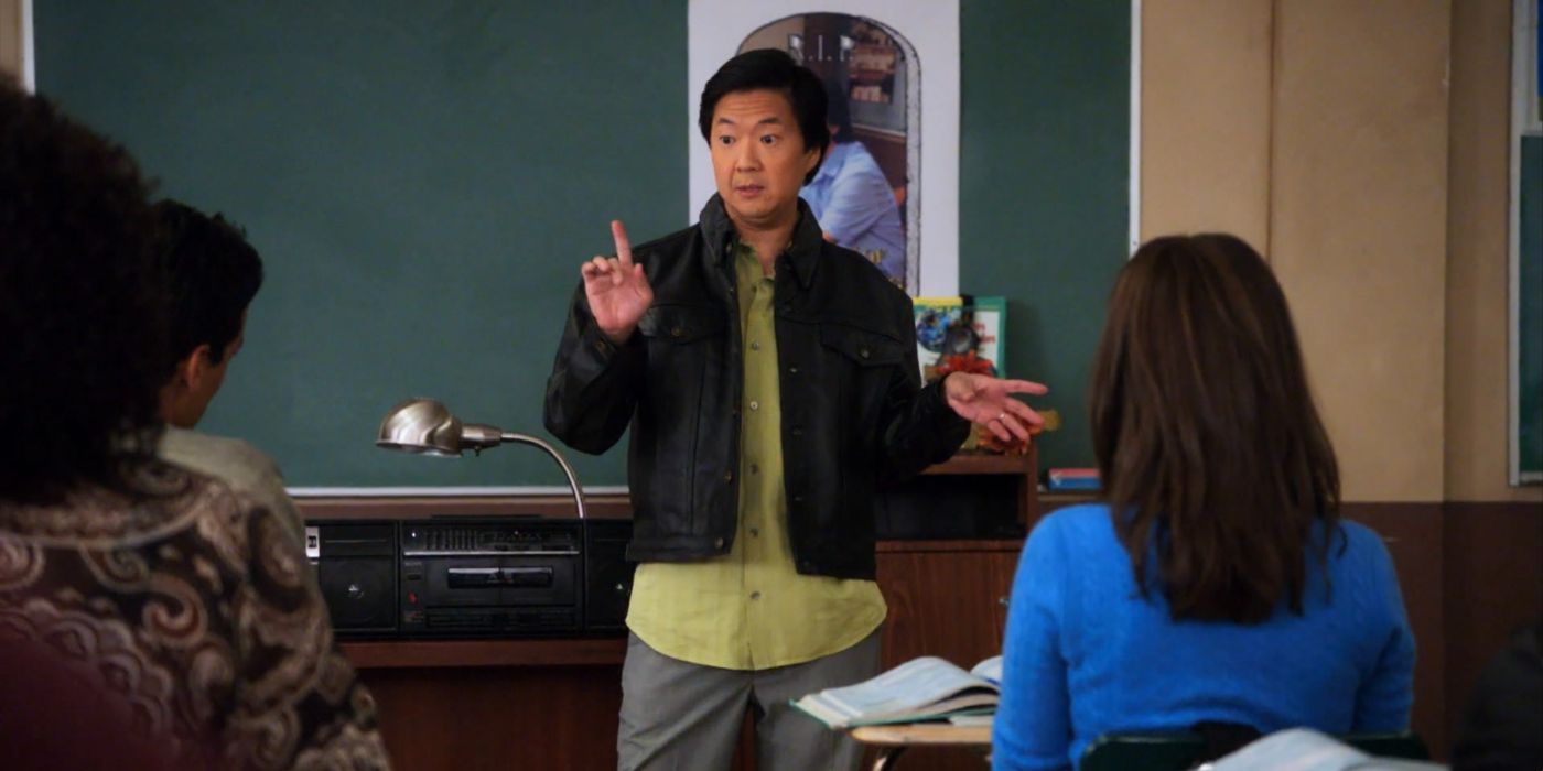 Ken Jeong as Ben Chang in "Community," Season 1, Episode 13, standing at the front of a classroom, holding up his right pointer finger. There is a boombox and lamp on the desk next to him.