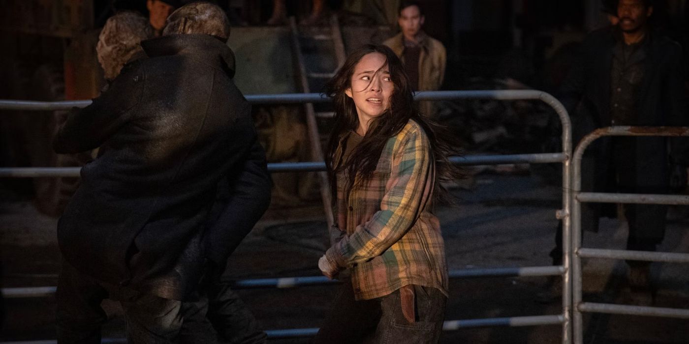 a woman inside a cage fights off the undead