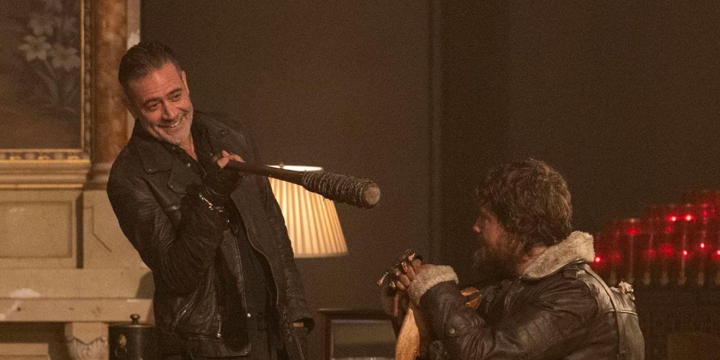 Jeffrey Dean Morgan as Negan holds his bat Lucille up to a cowering man