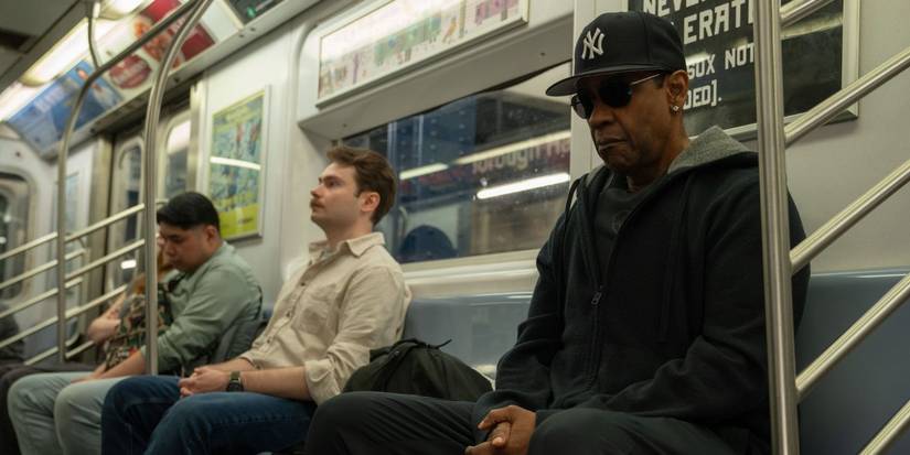 Denzel Washington wearing a Yankees cap and sunglasses while sitting in a subway train in Spike Lee's latest joint, Highest 2 Lowest.