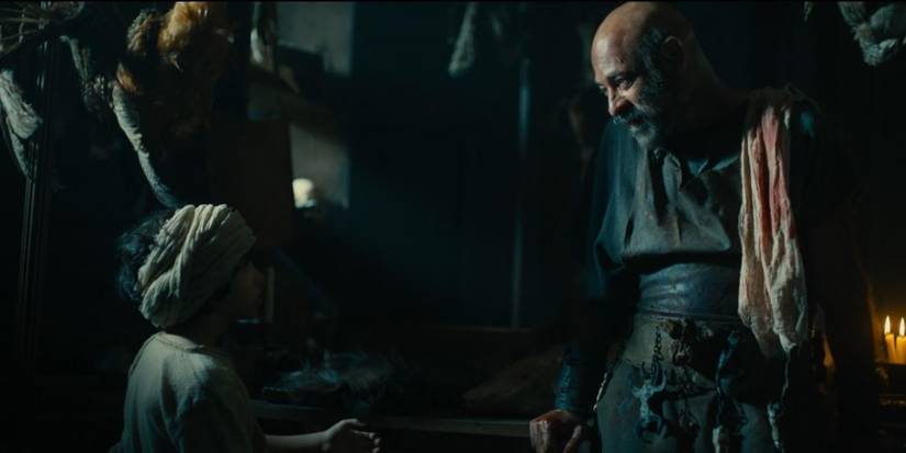 Ashraf Barhom as Doeg talks to a young boy in front of bloody carcasses of animals in House of David