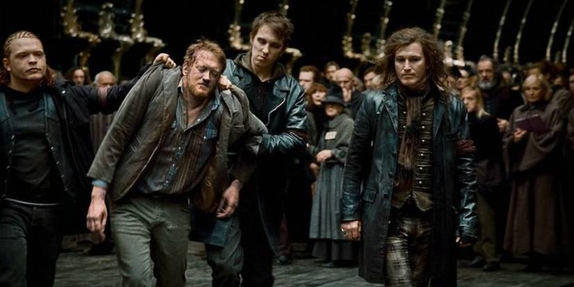 Dirk Cresswell is led past others in a crowd by three men in the Harry Potter film series.