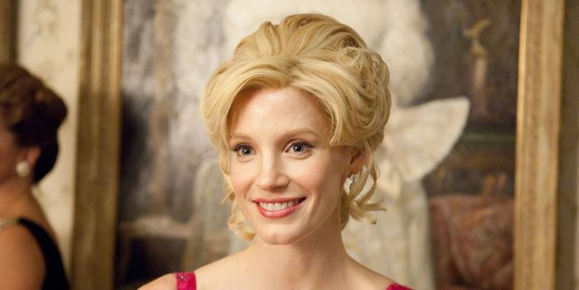 Jessica Chastain as Celia smiling at a party in a pink dress in The Help.