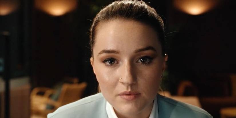 Kaitlyn Dever dalam Cuka Sari Apel menatap ke kamera dengan ekspresi serius.