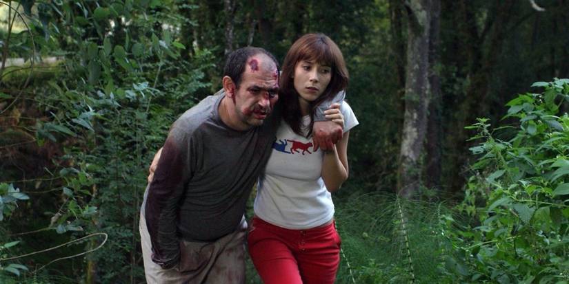 Karra Elejalde as Hector and Bárbara Goenaga as La Chica walk through the woods in Timecrimes