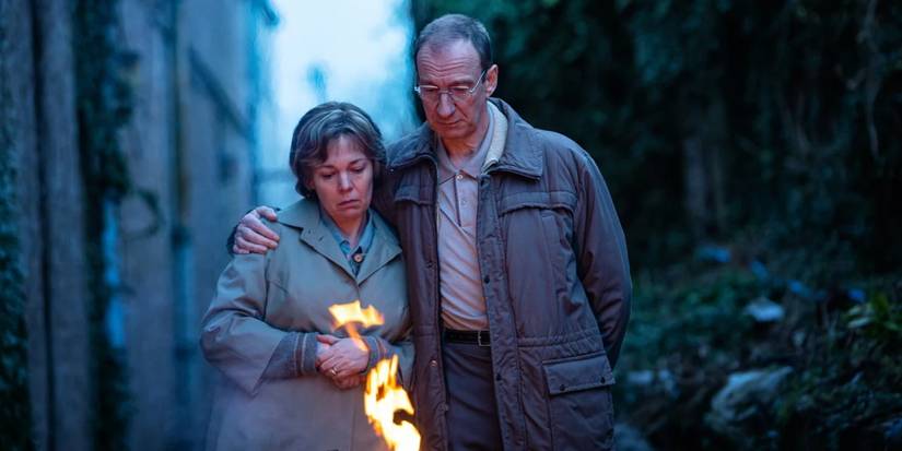 Olivia Colman as Susan and David Thewlis as Christopher watching a small fire in an alley in Landscapers.