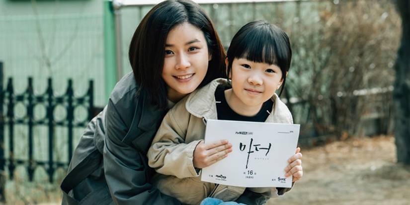 Lee Bo-young and Heo Yool hugging and showing a sign to the camera in Mother