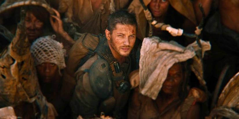 Max, played by Tom Hardy, looks up as Furiosa, played by Charlize Theron, ascends in Mad Max: Fury Road