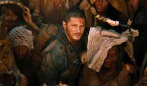 Max, played by Tom Hardy, looks up as Furiosa, played by Charlize Theron, ascends in Mad Max: Fury Road