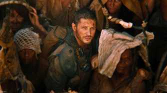Max, played by Tom Hardy, looks up as Furiosa, played by Charlize Theron, ascends in Mad Max: Fury Road