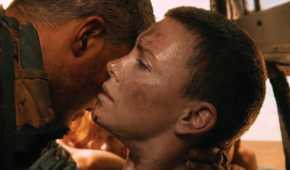 Max, played by Tom Hardy, holds an injured Furiosa, played by Charlize Theron, up so she can whisper to him in Mad Max: Fury Road
