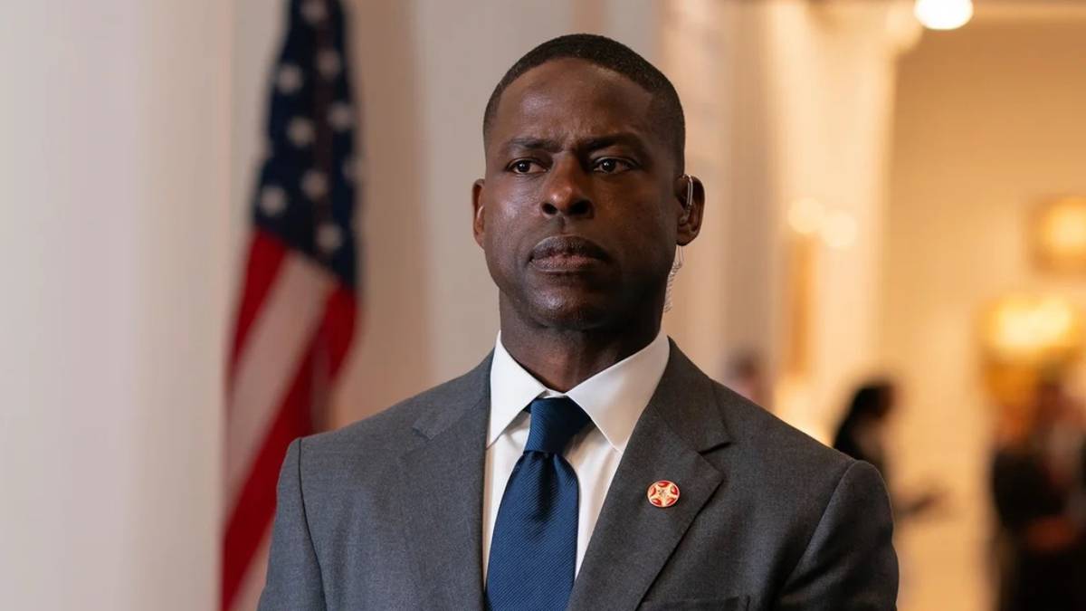 Sterling K. Brown as Agent Xavier Collins in Paradise stands in front of a US flag