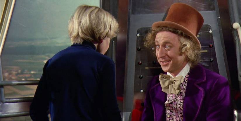 Peter Ostrum and Gene Wilder talking as they ride in a machine in Willy Wonka and the Chocolate Factory.