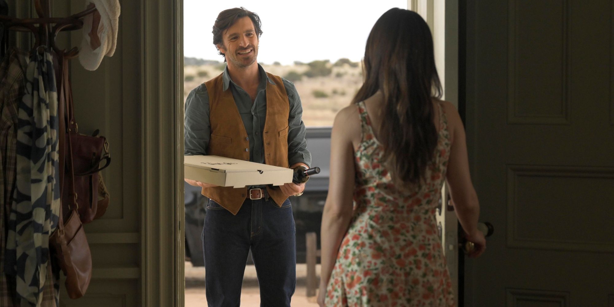 Eoin Macken as Davis Collins standing at the door of Minka Kelly as Quinn with a pizza in Ransom Canyon