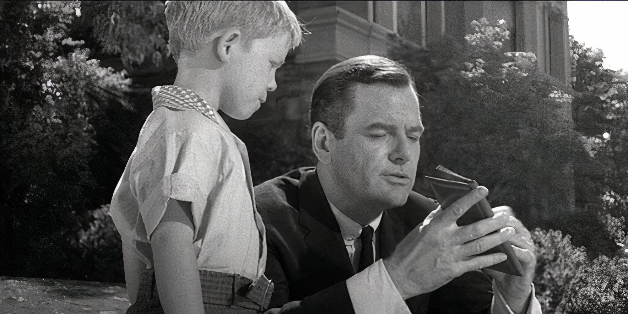 A young Ron Howard stands next to Gig Young crouching down in The Twilight Zone episode Walking Distance.