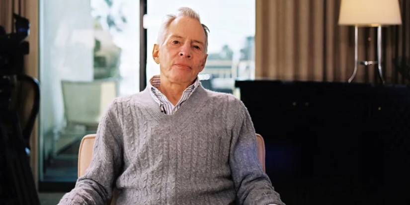 Robert Durst in 'The Jinx' wearing a grey sweater looking into the camera.