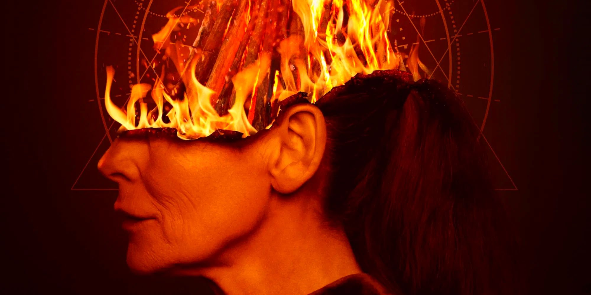 Veronica, played by actor Alice Krige, viewed sideways on, with the top half of her head on fire, against a dark occultish background.