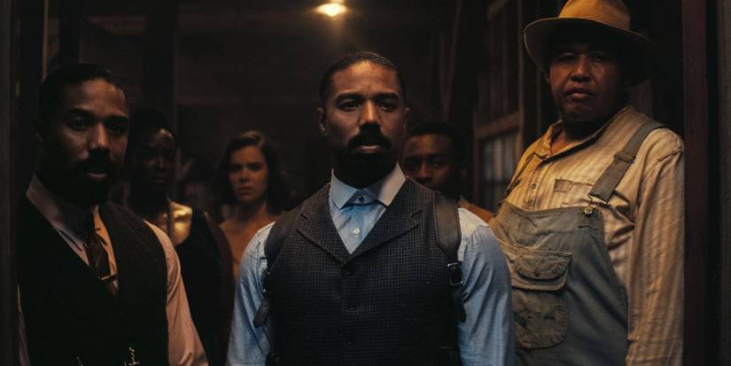 Michael B. Jordan as Smoke / Stack, Wunmi Mosakuas as Annie, and Hailee Steinfeld Mary staring through an open door in Sinners