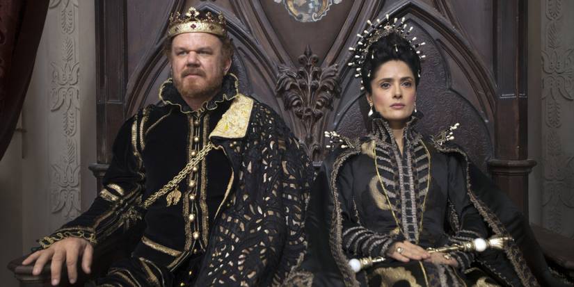 The King and Queen of the Longtallis (John C. Reilly and Salma Hayek) sit upon their thrones adorned in black and gold robes in 'Tale of Tales' (2015).
