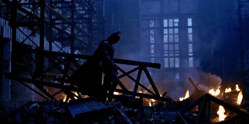 Batman berdiri tegak di atas kehancuran bahan peledak Joker di The Dark Knight.