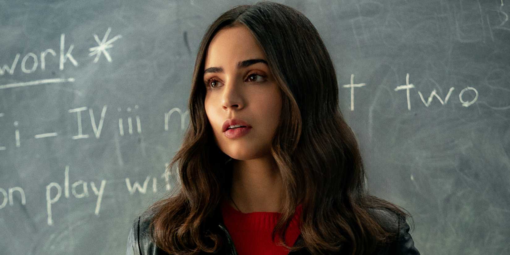Sofia Carson as Alex Rose standing in front of a chalkboard in The Life List