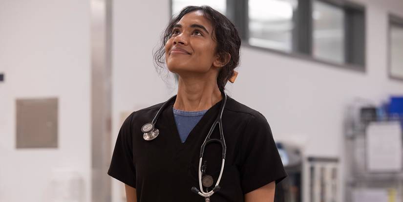 Supriya Ganesh as Dr. Mohan smiling up at the patient board in The Pitt Season 1, Episode 15.
