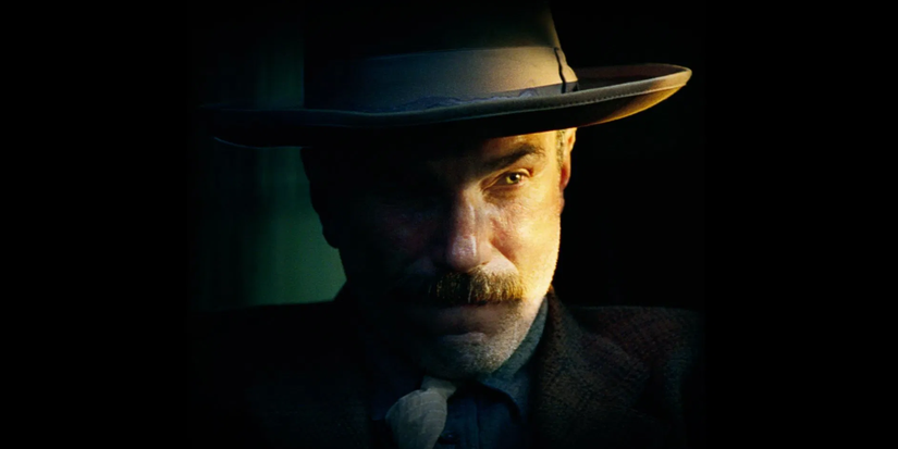 Daniel Plainview with a fedora looks to the distance with dramatic lighting in There Will Be Blood.