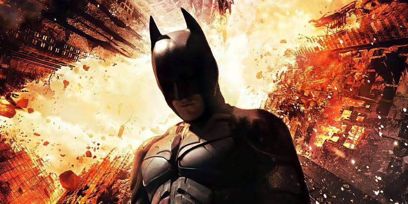 Batman (Christian Bale) with a burning city behind on the poster for 'The Dark Knight Rises'.