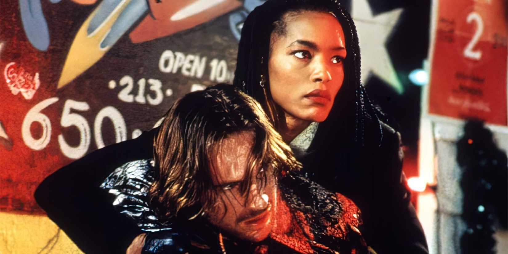 Ralph Fiennes is helped up off the ground by Angela Bassett in Kathryn Bigelow's 'Strange Days'