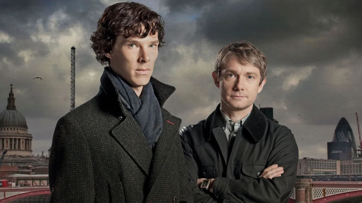 Benedict Cumberbatch and Martin Freeman as Sherlock Holmes and Dr. Watson look ahead with a city backdrop.