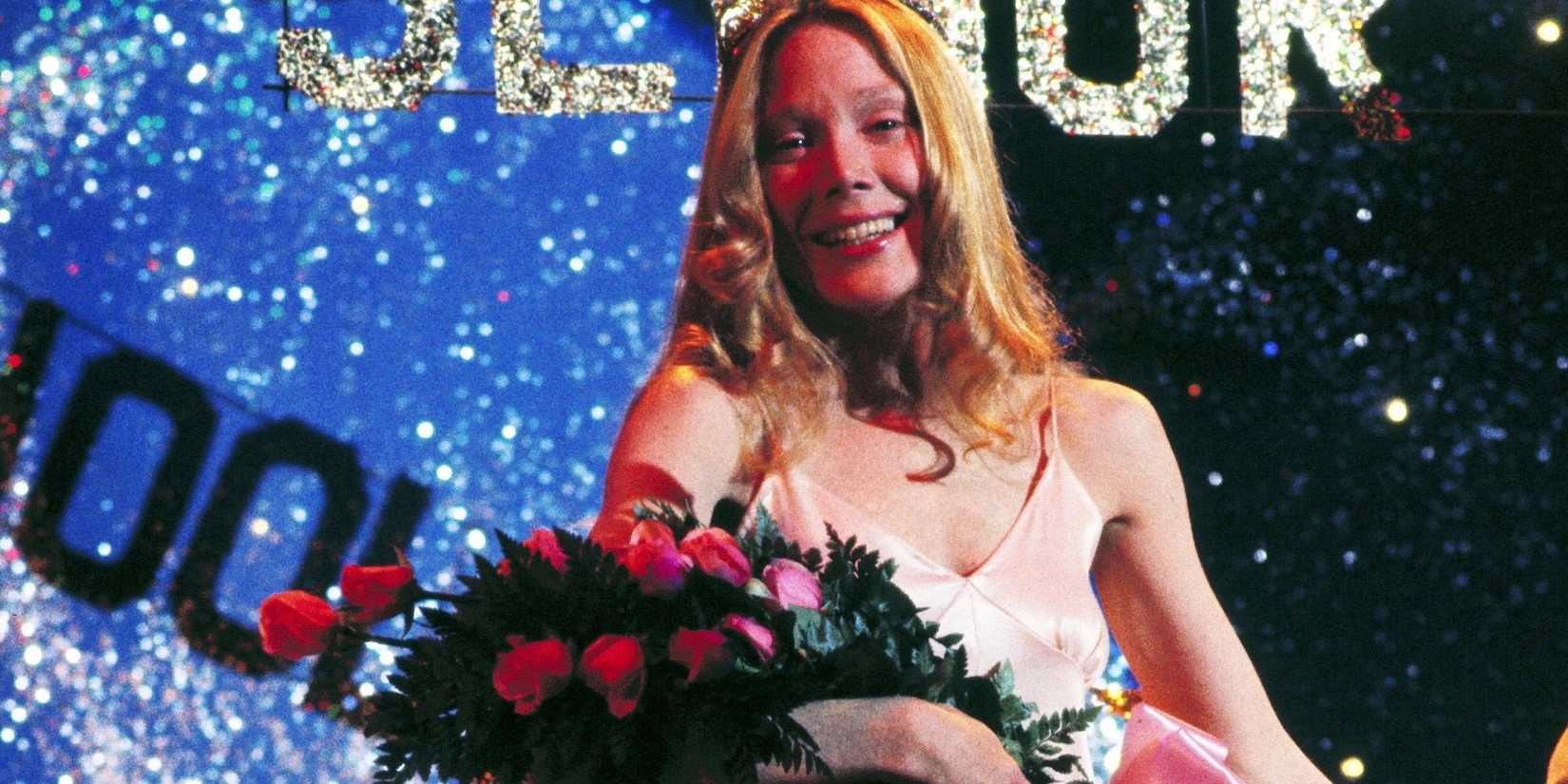 Sissy Spacek as Carrie holding flowers and wearing a tiara on stage, smiling in Carrie.