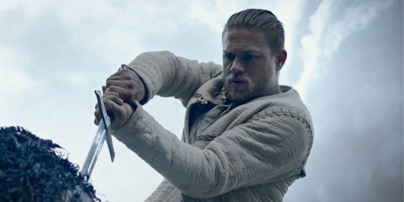 Charlie Hunnam as Arthur pulling the sword from the stone in King Arthur: Legend of the Sword.