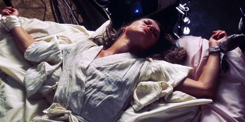 An uncounscious woman tied to a bed in demon seed