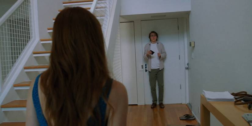 Zoe Kazan in a blue dress looks at Paul Dano who is standing a distance away in Ruby Sparks.