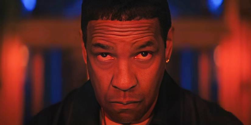 Actor Denzel Washington as David King, looking straight ahead in a room illuminated in blue and red, in Highest 2 Lowest.