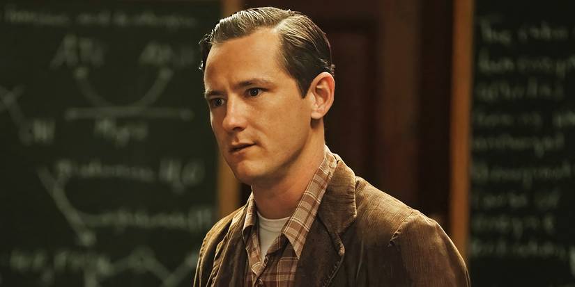 Lewis Pulman as Calvin Evans standing in front of a blackboard in Lessons in Chemistry