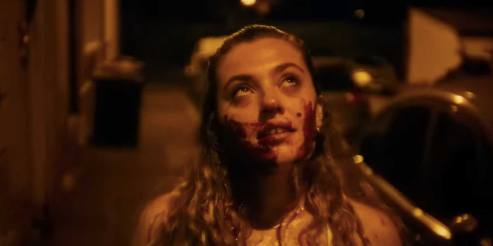 Anais, played by actress Lucille Guillaume, standing in a dark empty street with blood around her mouth, looking up dreamily in MadS.