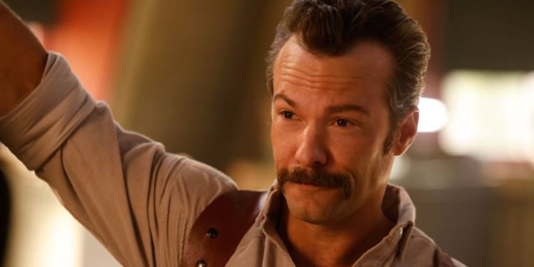 Kyle Schmid as young Franks leaning on doorframe in NCIS: Origins.