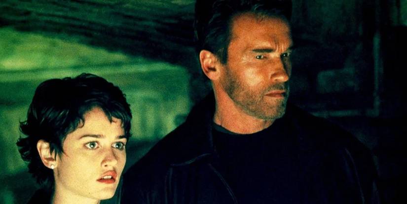 Robin Tunney and Arnold Schwarzenegger standing side by side in End of Days