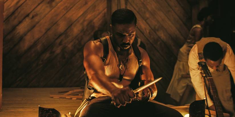 Michael B. Jordan sharpening a wooden stake in Sinners